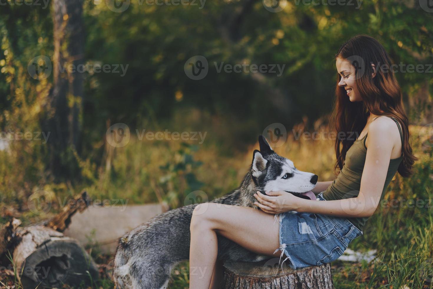donna e sua rauco cane felicemente giocando all'aperto nel il parco tra il alberi Sorridi con denti nel il autunno camminare con sua animale domestico foto