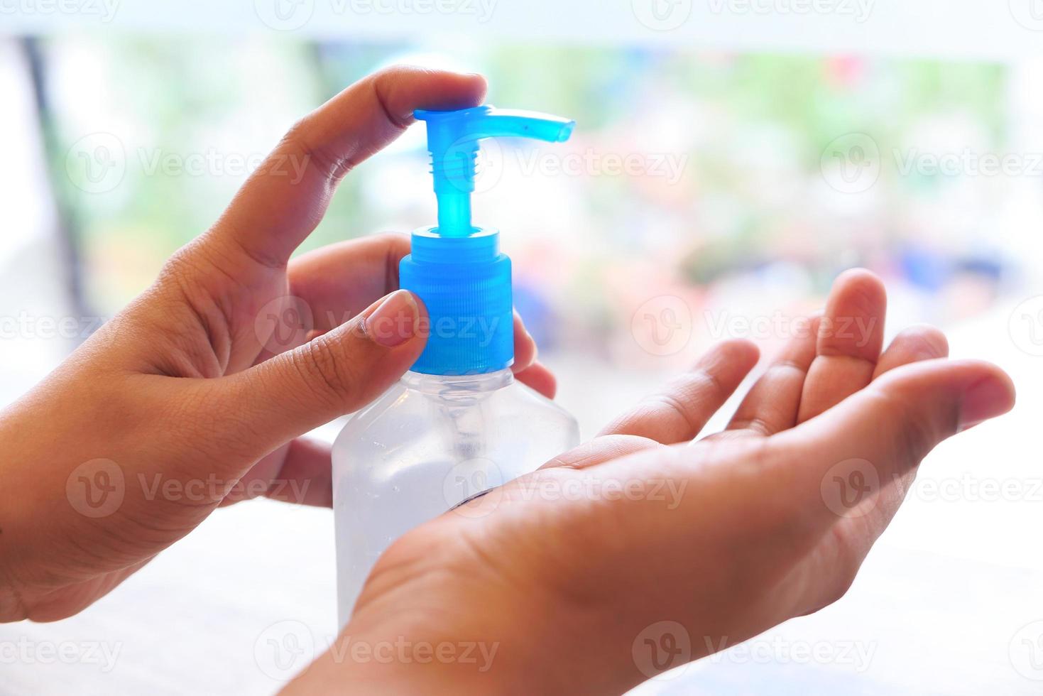 persona che utilizza disinfettante per le mani foto