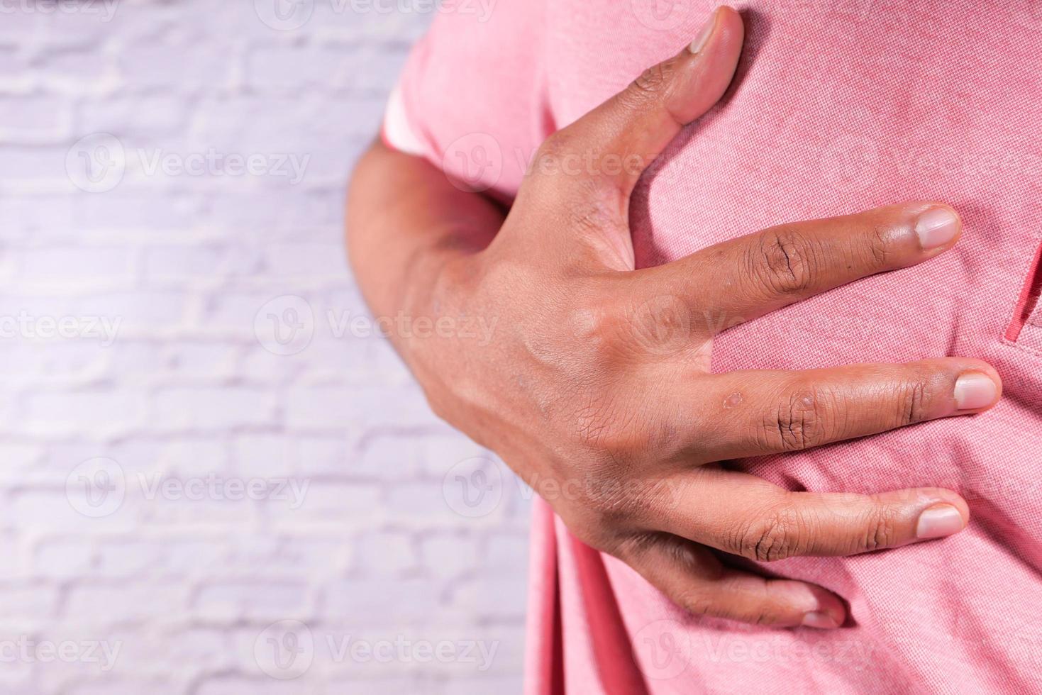 uomo che tiene il petto nel dolore foto