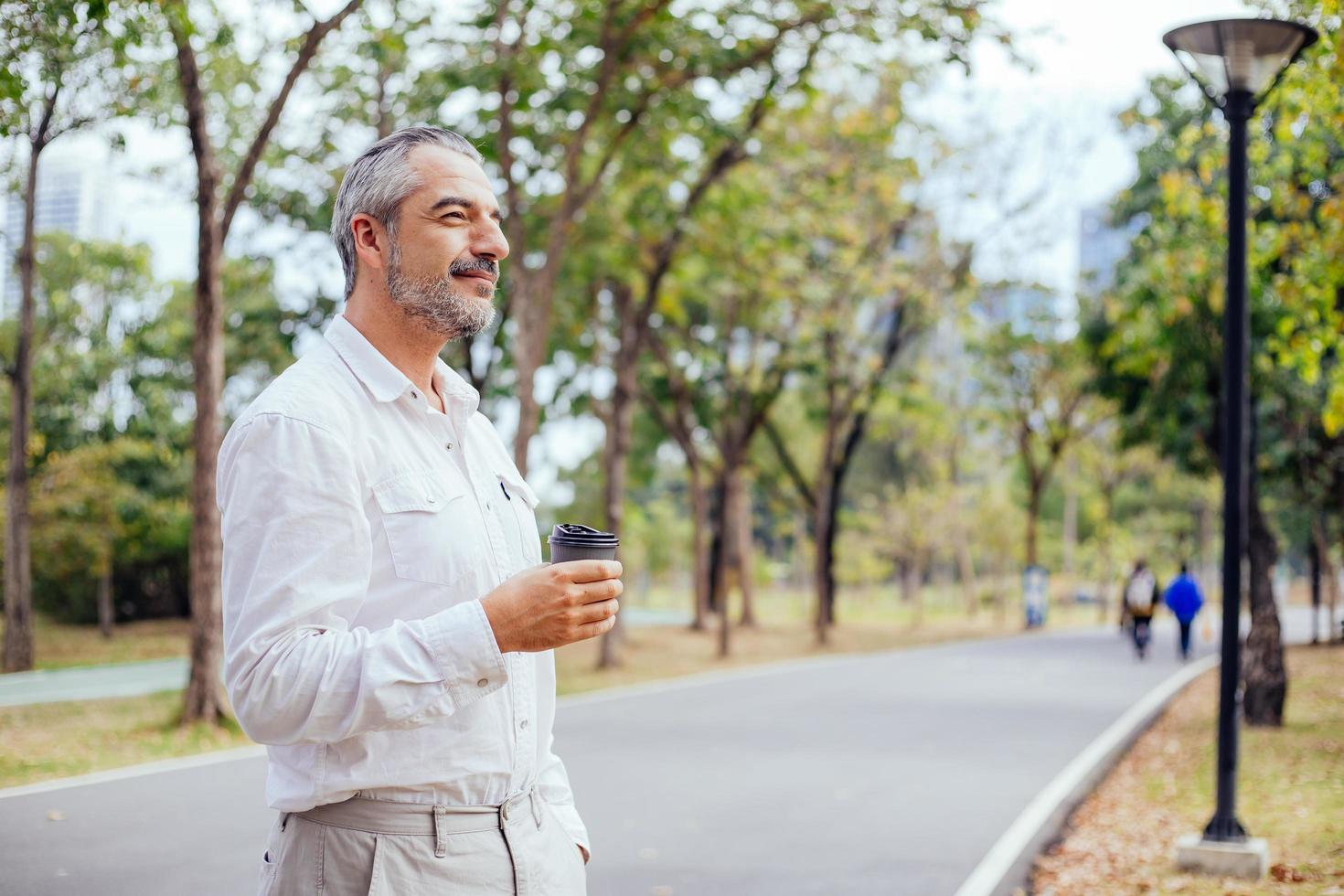 uomo maturo con caffè in un parco foto