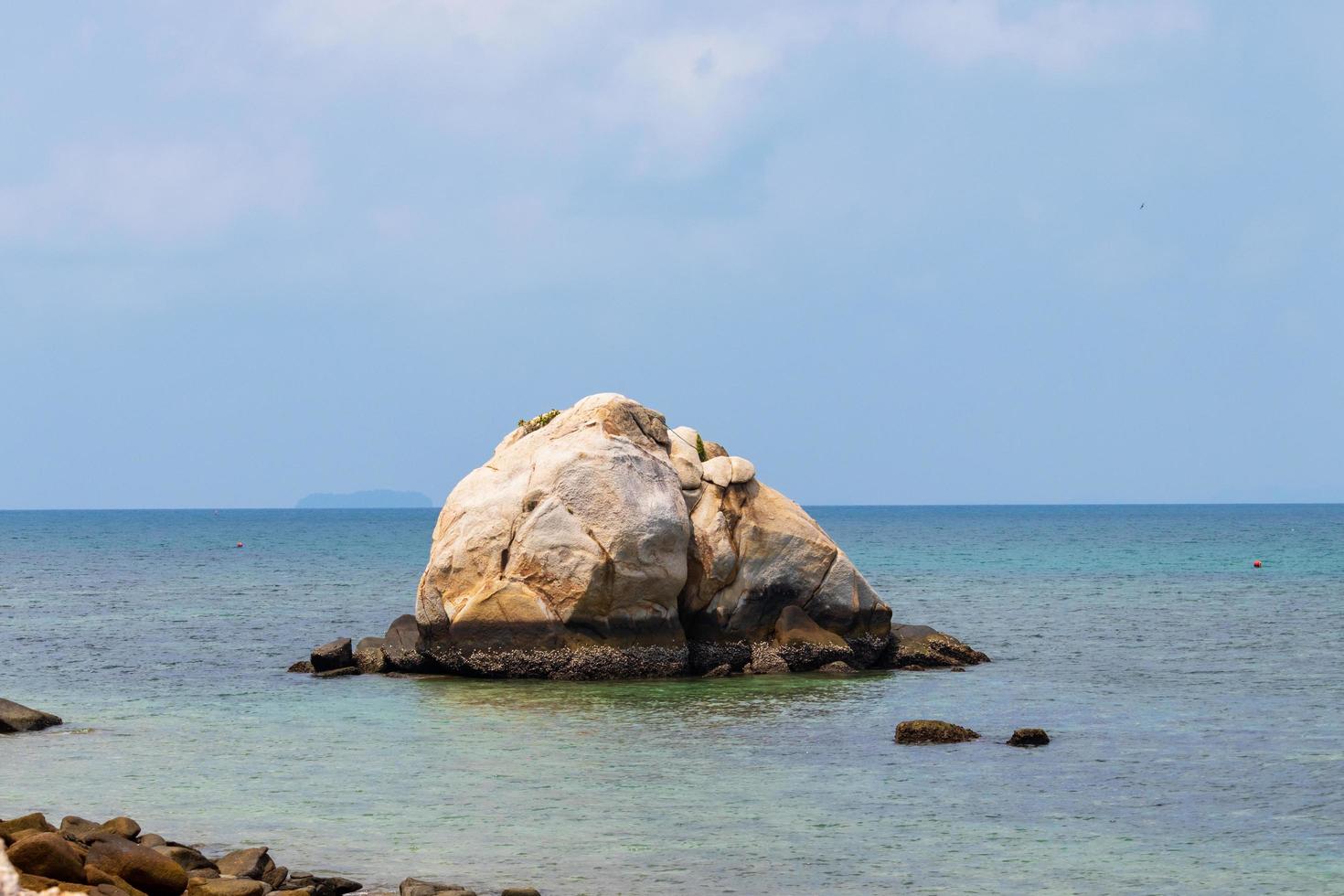 roccia in mezzo al mare tropicale foto