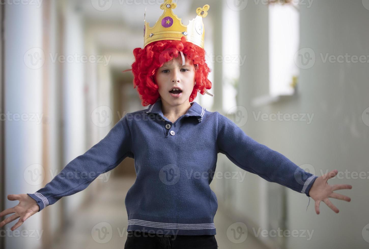 bambino nel un' rosso parrucca e un' corona. clown ragazzo foto