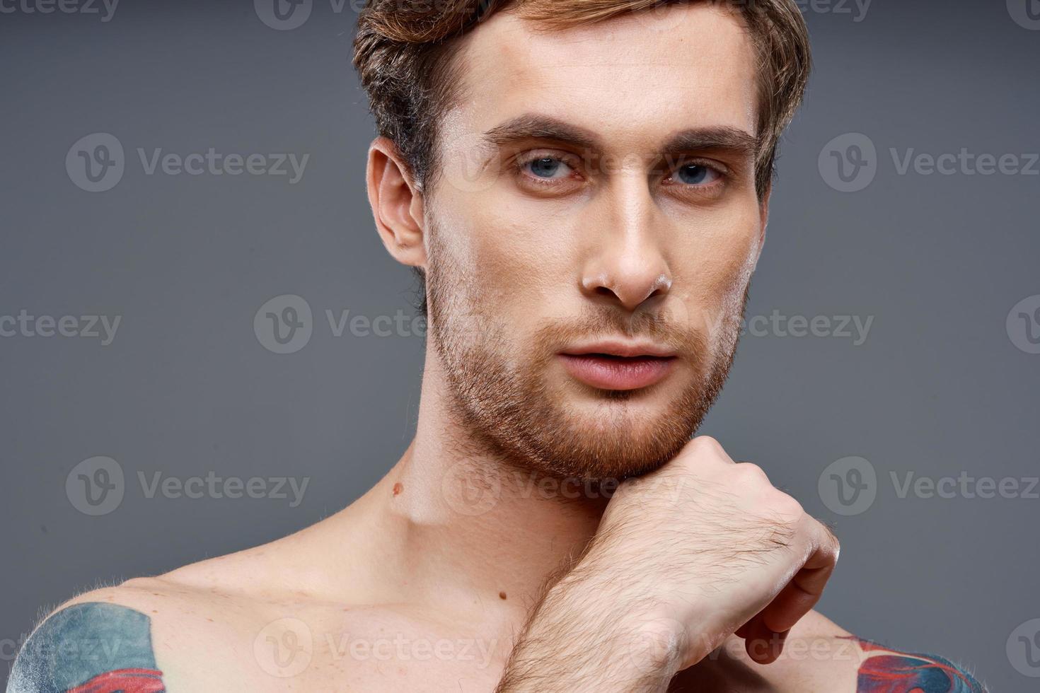 ritratto di un' sportivo uomo con un' pompato torso tatuaggio biondo modello ritagliata Visualizza foto