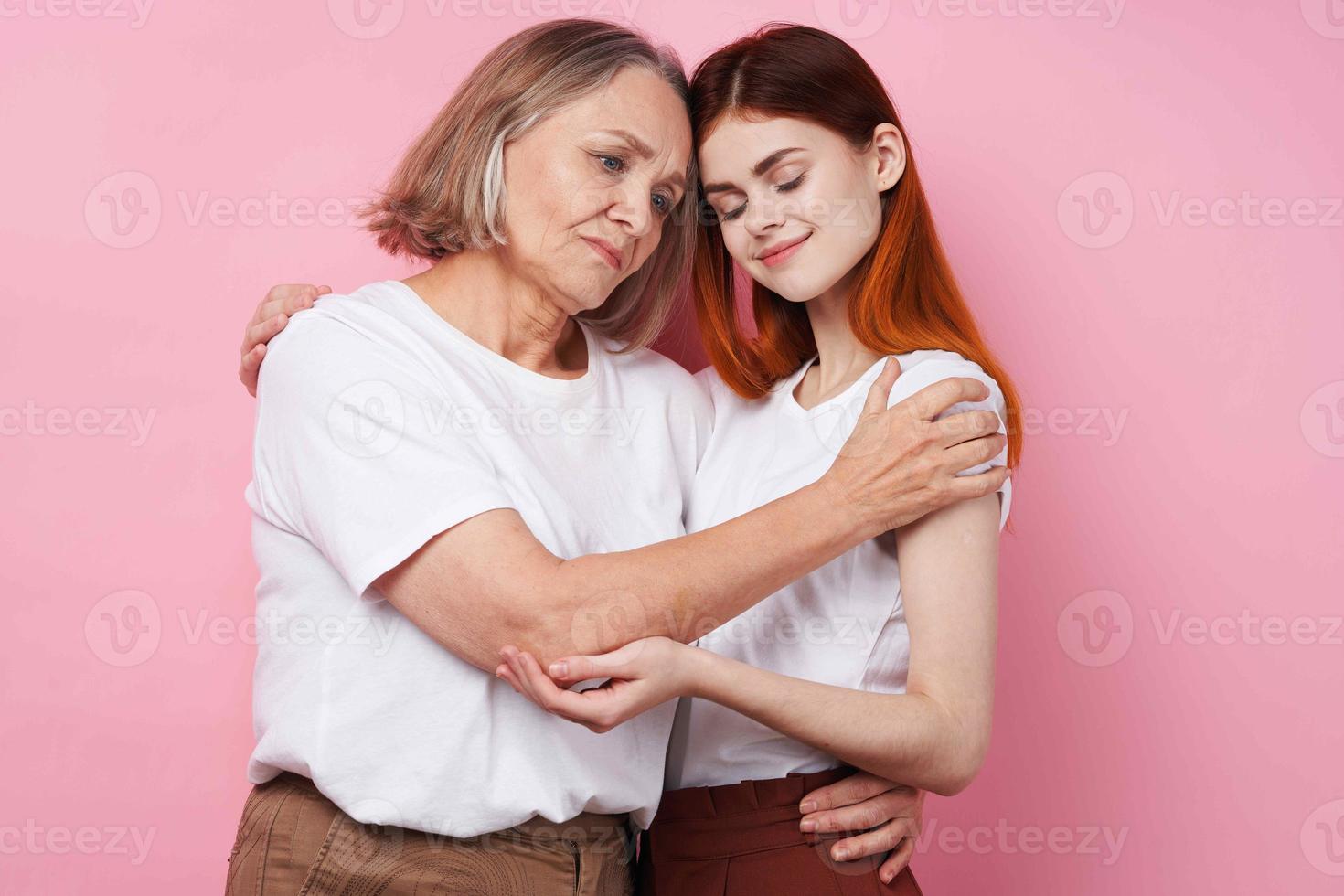 nonna e nipotina siamo in piedi lato di lato famiglia amicizia divertimento rosa sfondo foto