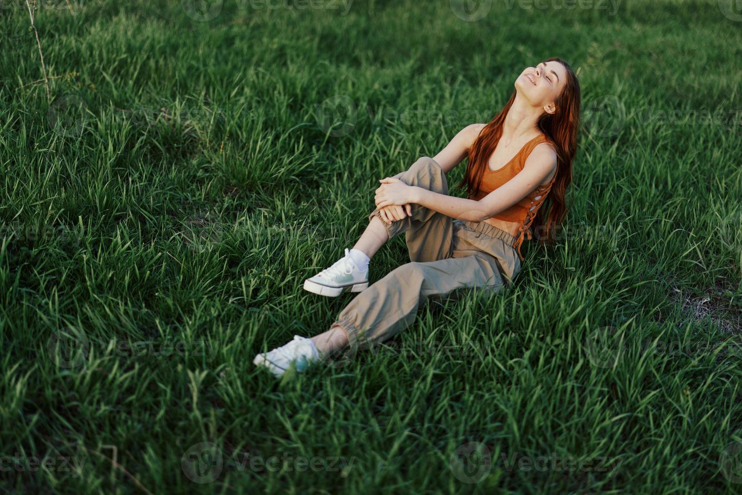 stile di vita estate donne su vacanza nel il parco seduta su il verde erba guardare a il telecamera e sorridente foto