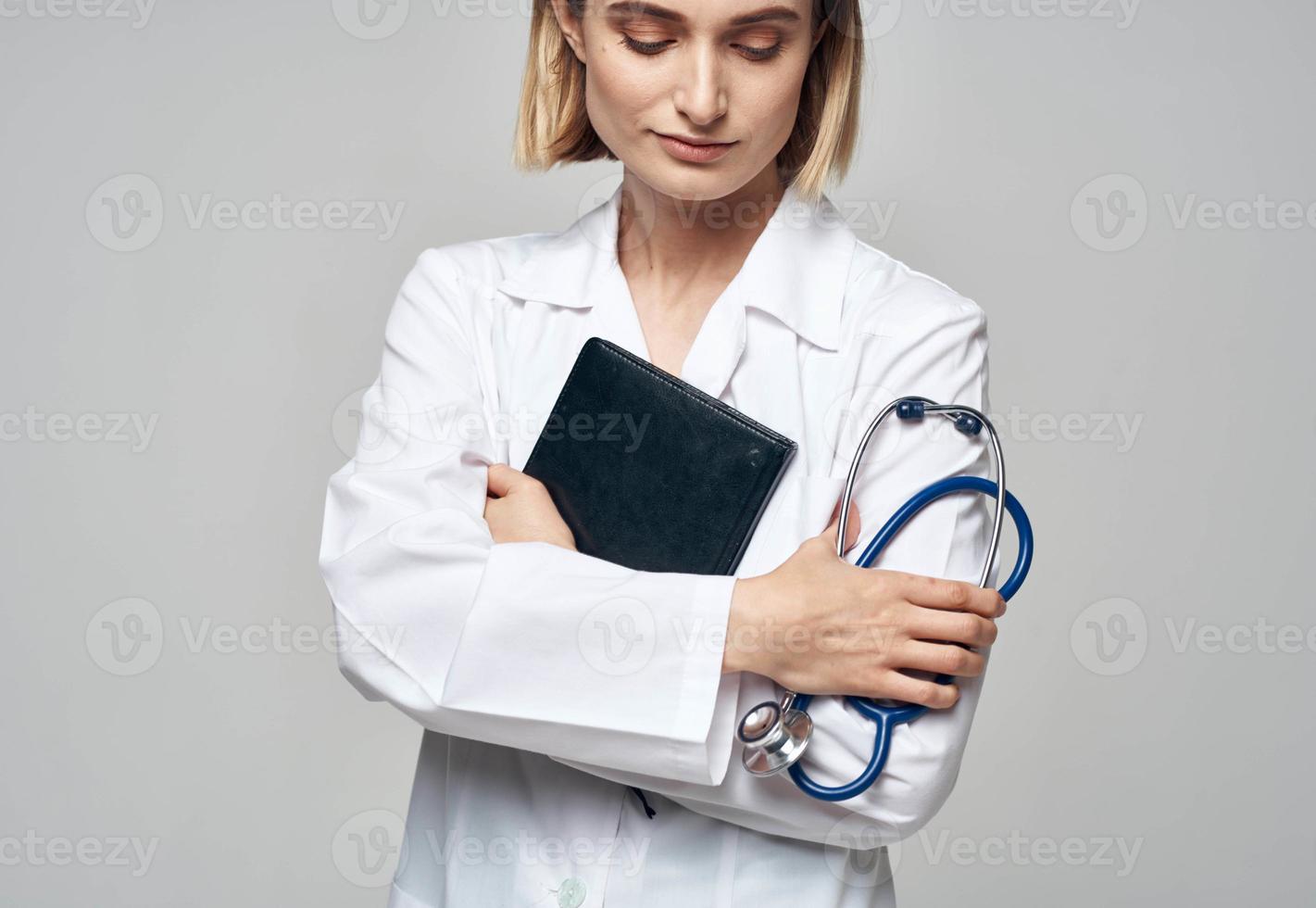 donna medico con stetoscopio e medico toga documenti nel mani foto