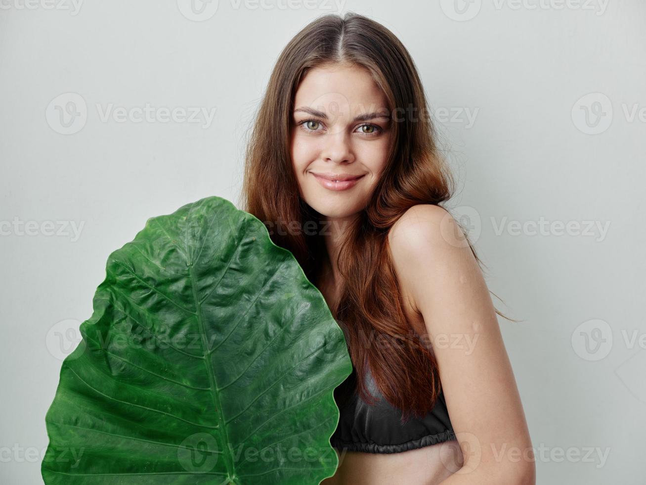 bella donna nel costume da bagno verde foglia esotico fascino leggero sfondo foto