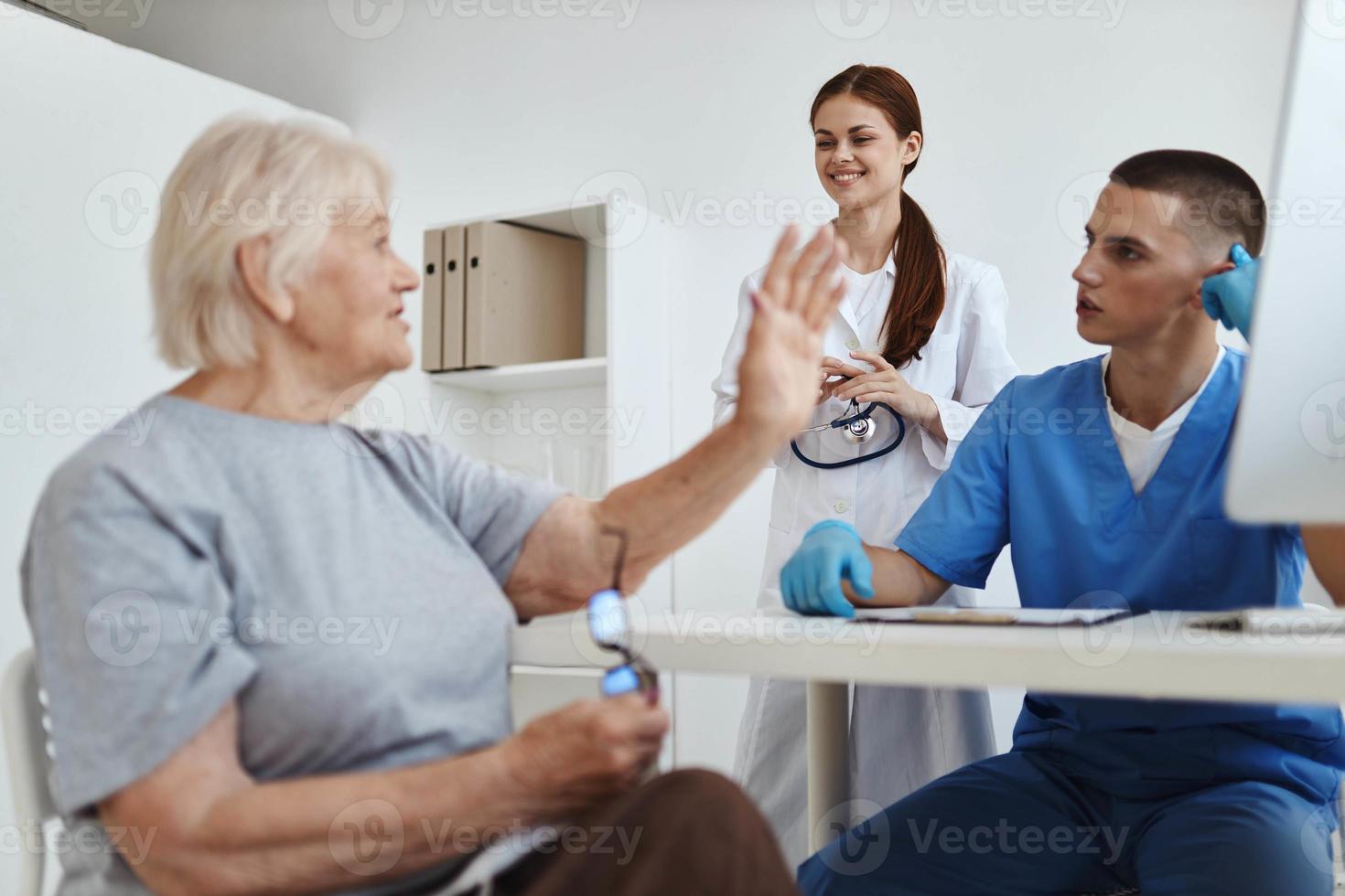 anziano donna nel il medico ufficio con un' infermiera discussione servizio consegna foto