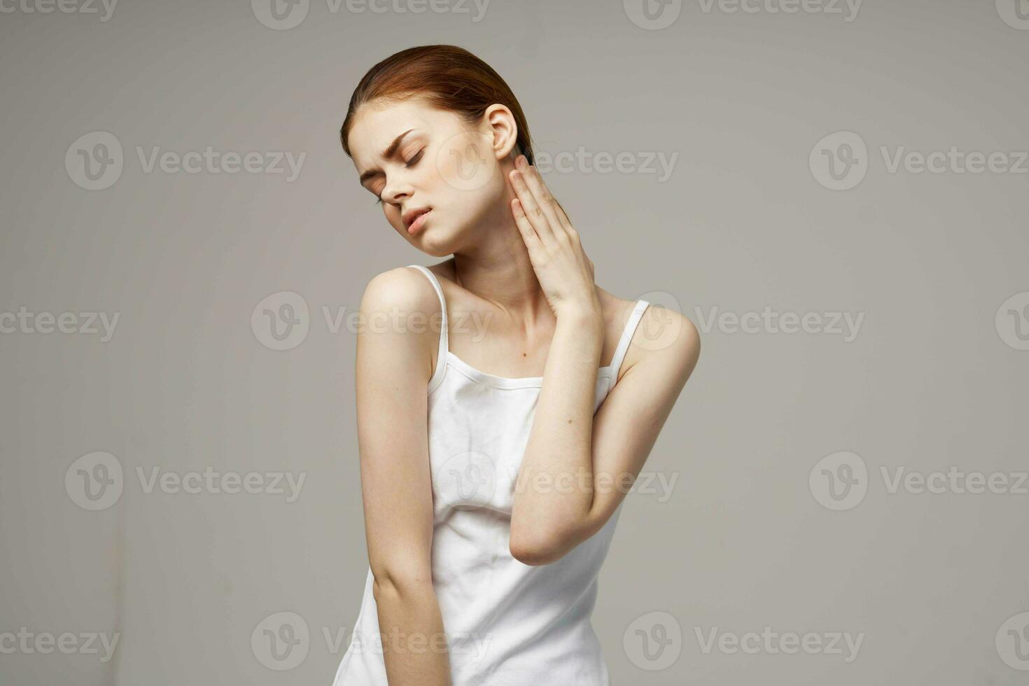 donna nel bianca maglietta Tenere su per il collo Salute i problemi comune leggero sfondo foto