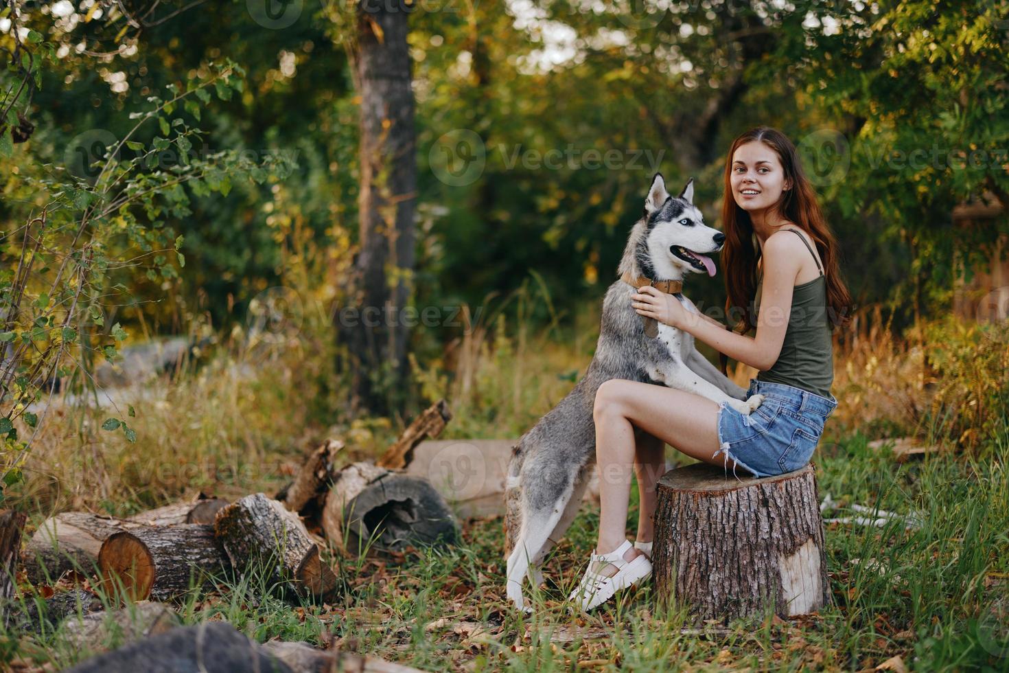 donna e sua rauco cane felicemente giocando all'aperto nel il parco tra il alberi Sorridi con denti nel il autunno camminare con sua animale domestico foto