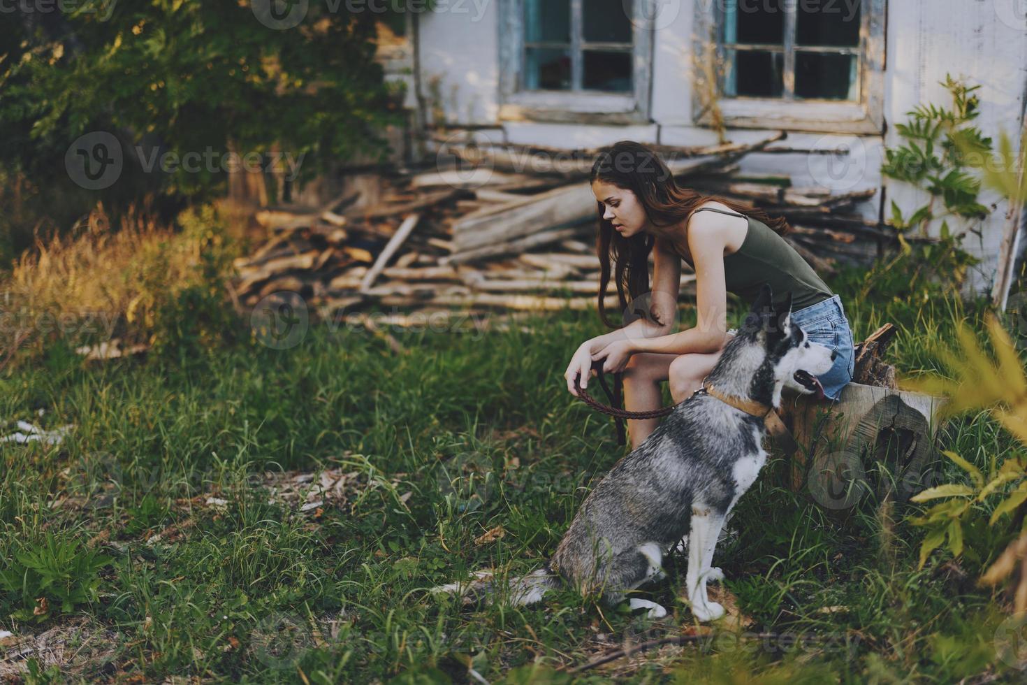 donna e sua rauco cane felicemente giocando all'aperto nel il parco tra il alberi Sorridi con denti nel il autunno camminare con sua animale domestico foto