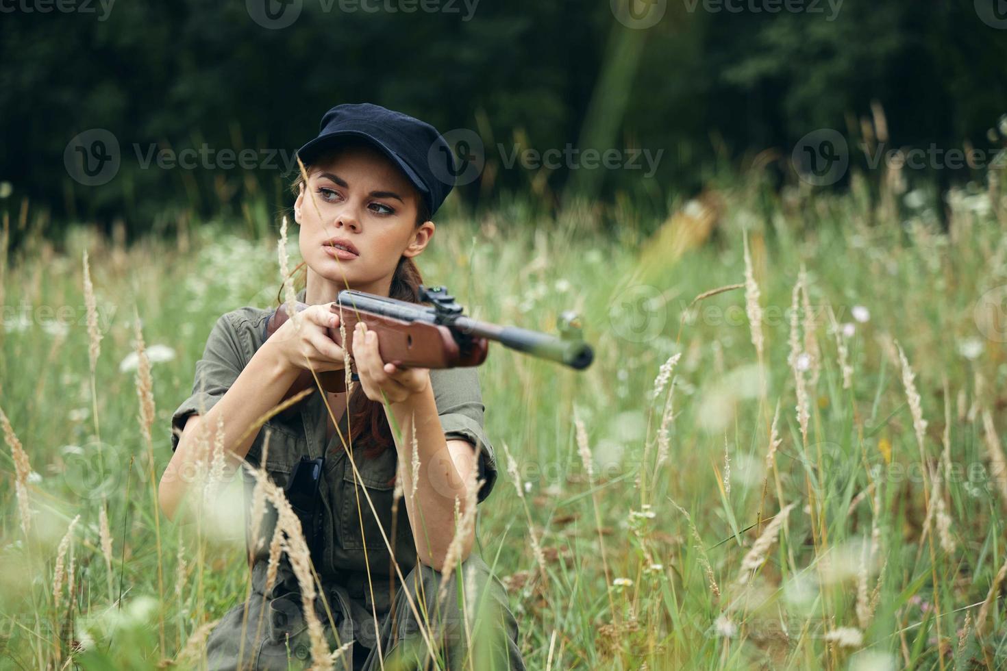 donna su all'aperto a caccia per riparo con Armi foto