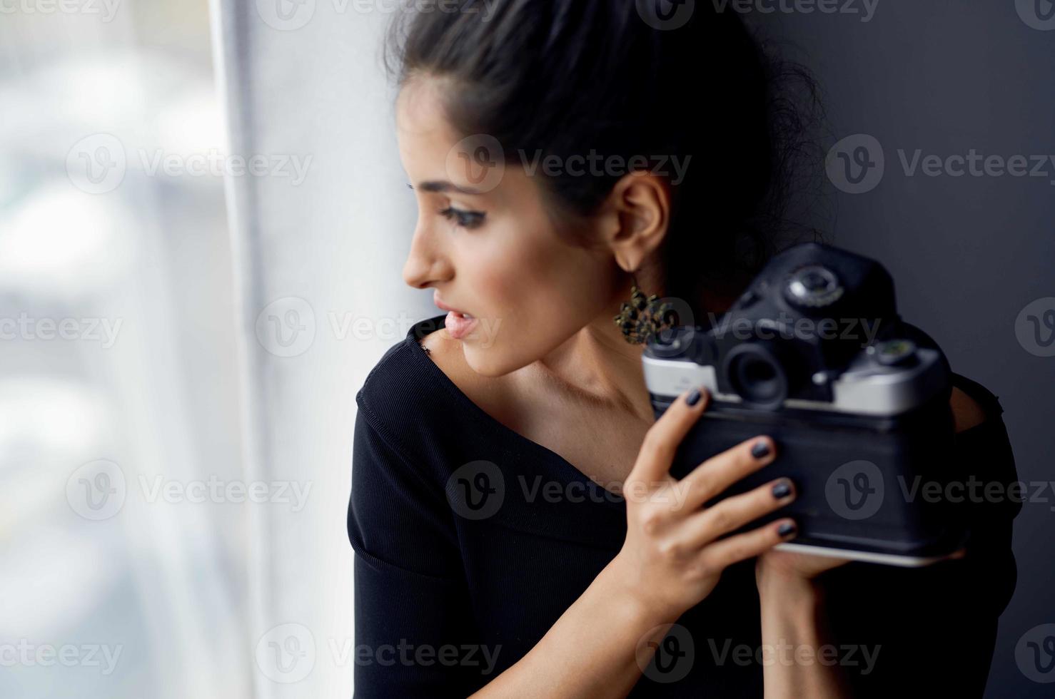bella donna Tenere un' telecamera vicino il finestra decorazione moda stile di vita studio foto