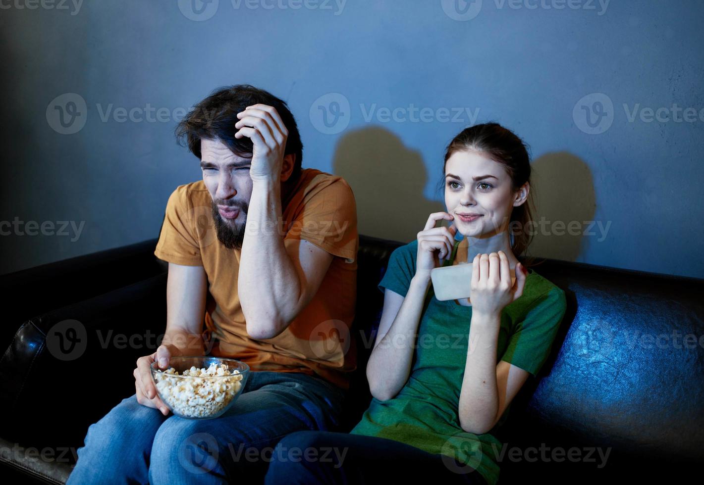 un' uomo e un' donna siamo Guardando tv nel il sera in casa foto