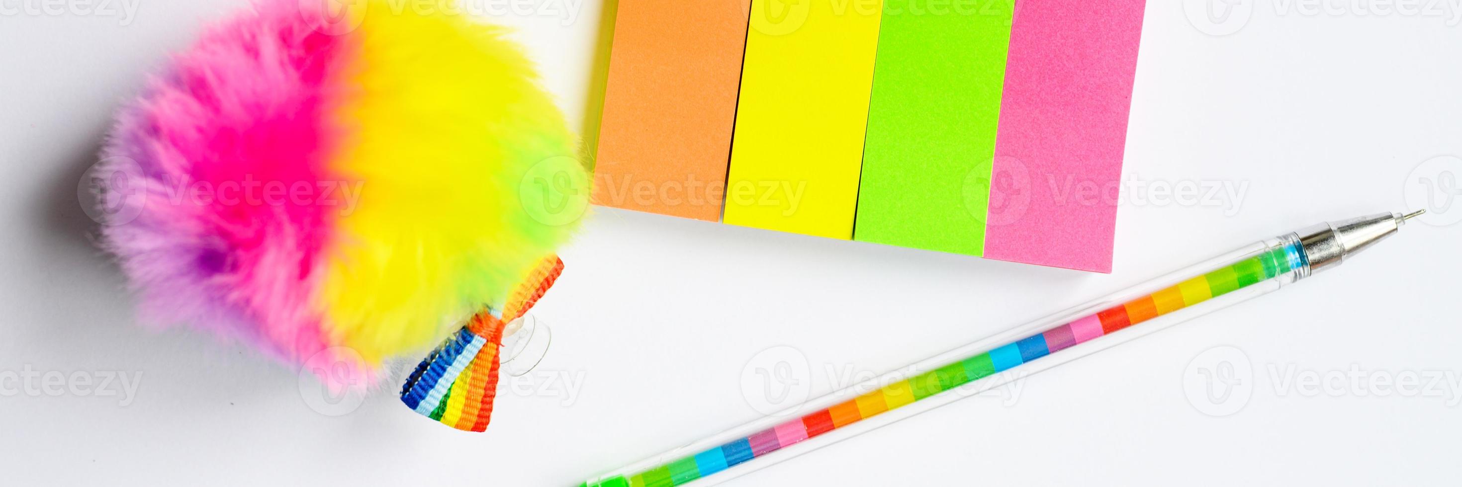 adesivi multicolori e una penna su sfondo bianco foto