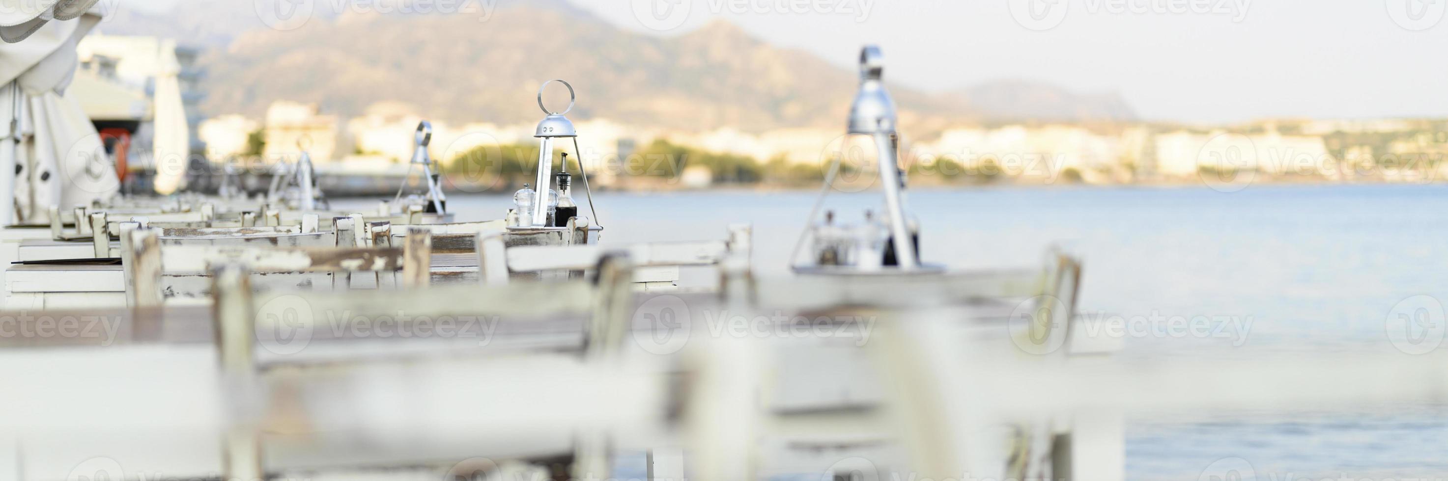 tavoli del caffè sull'argine mediterraneo del mare foto