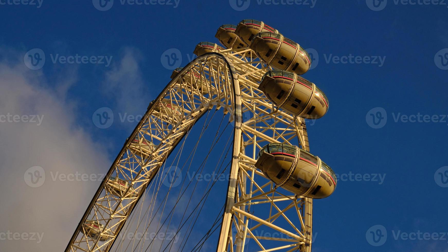 Ferris ruota nel il divertimento parco su sfondo di blu cielo con nuvole. Basso angolo Visualizza di un' grande Ferris ruota. foto