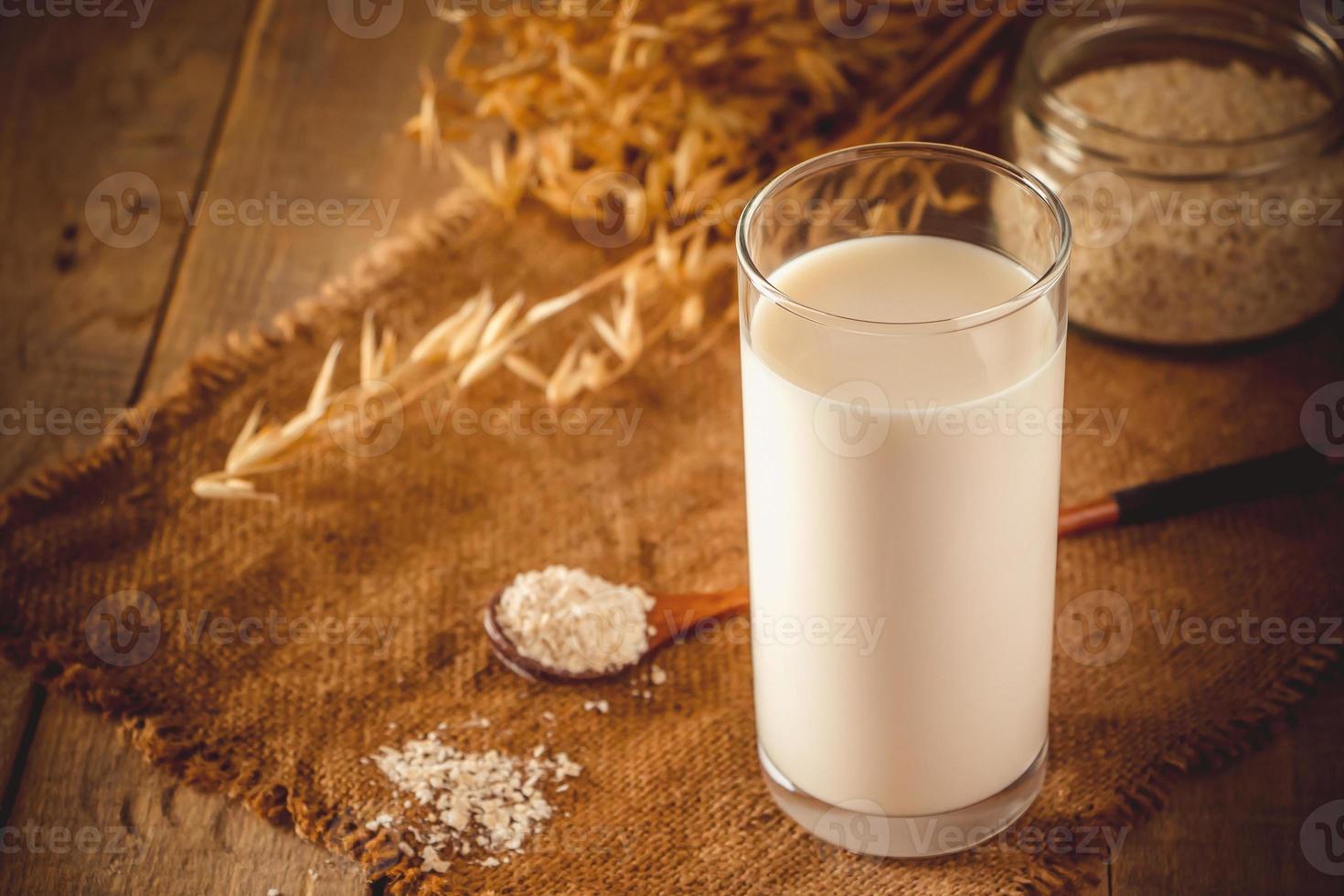 bicchiere di latte d'avena su uno sfondo di legno foto