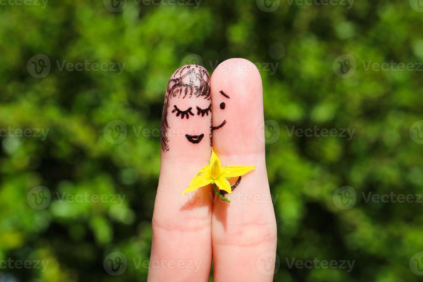 viso dipinto su dita. uomo è dando fiori per un' donna. foto