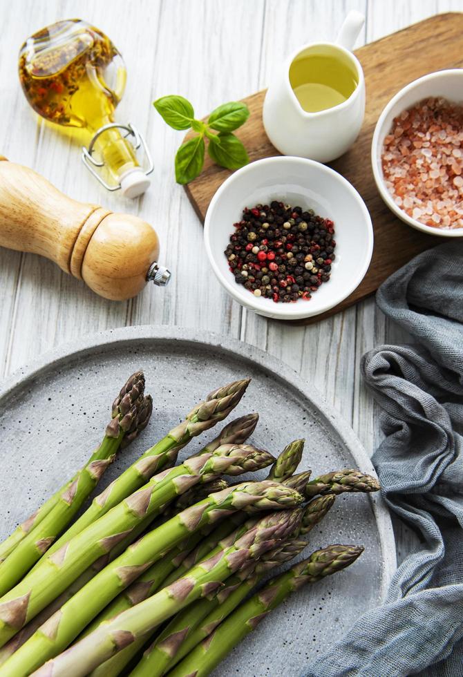 mazzo di gambi di asparagi crudi con spezie diverse foto