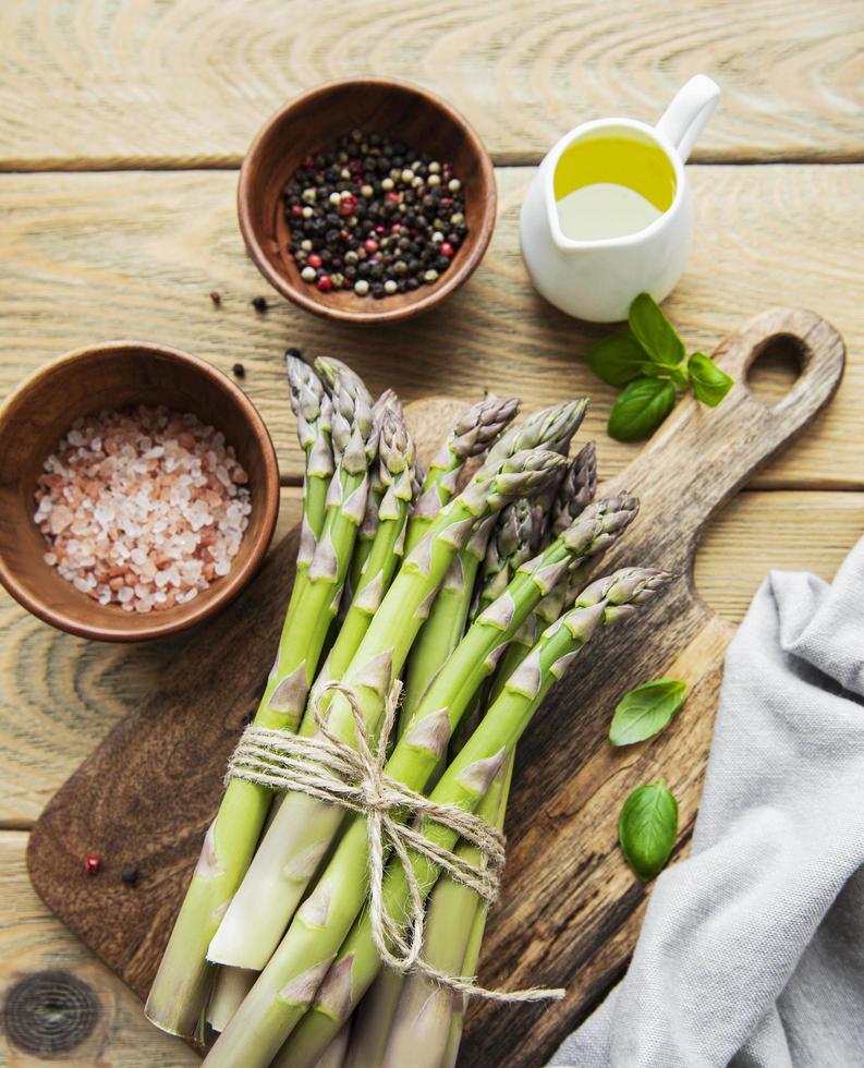 mazzo di gambi di asparagi crudi con spezie diverse foto