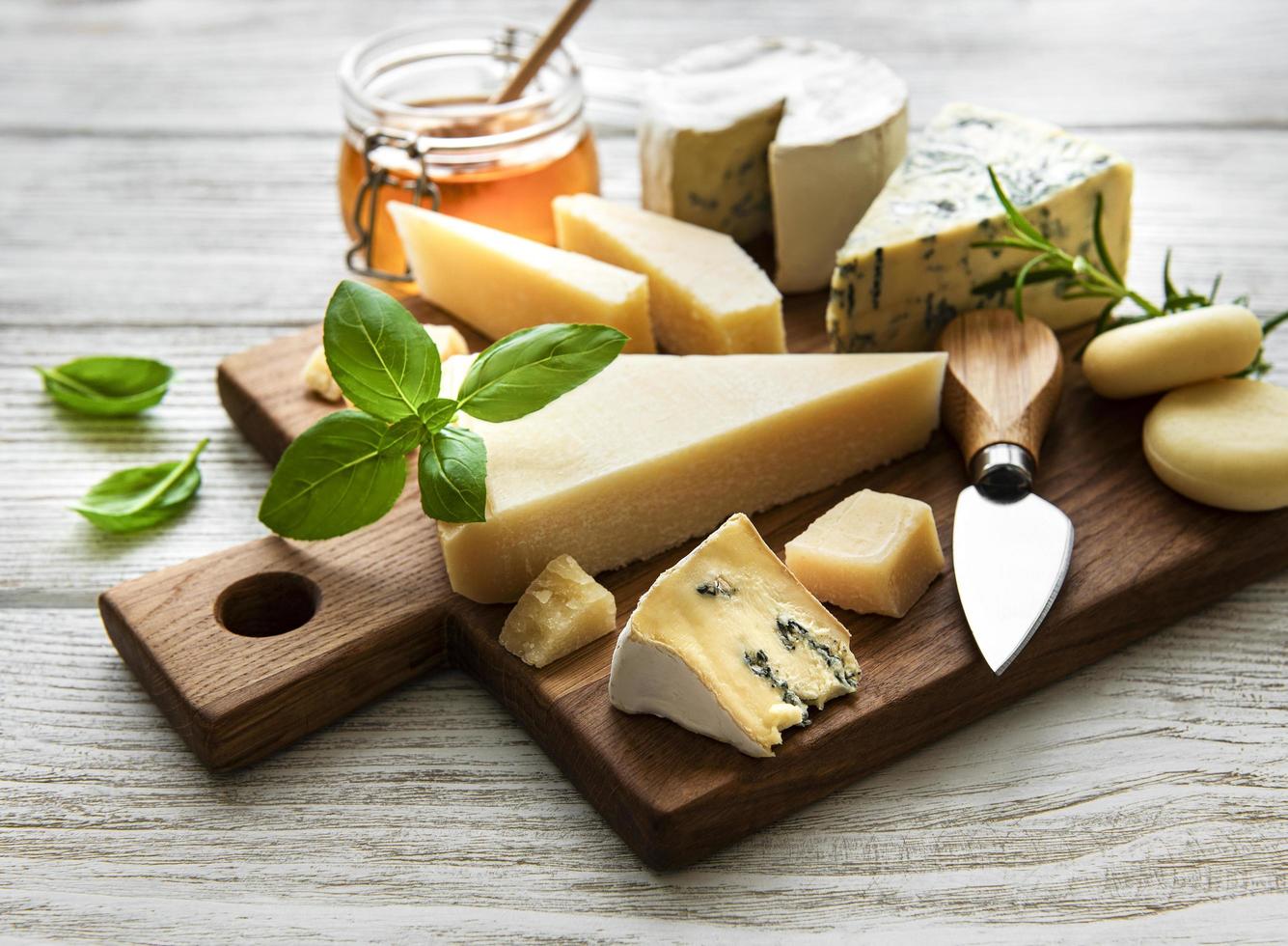 vari tipi di formaggio su uno sfondo bianco di legno foto