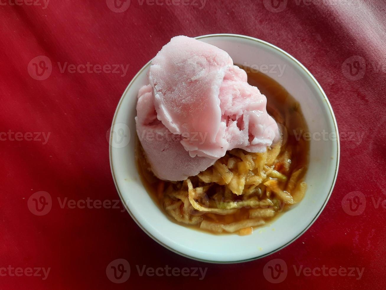 un' rujak o speziato frutta insalata piatto sormontato con fragola ghiaccio crema foto