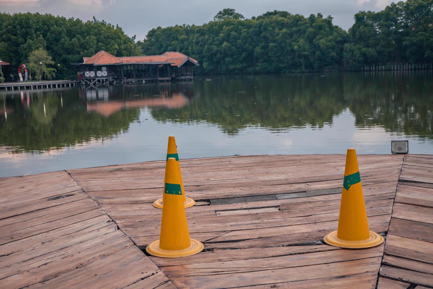 arancia perno per avvertimento buco su il di legno ponte al di sopra di il lago. il foto è adatto per uso per avventura soddisfare media, natura manifesto e foresta sfondo.