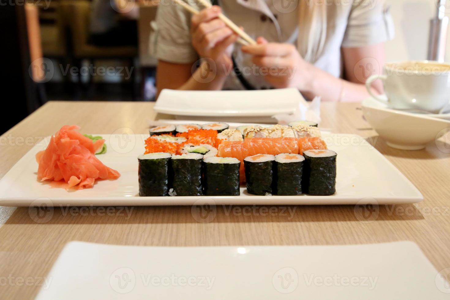 giapponese cucina, mani con bastoncini nel il sfondo foto
