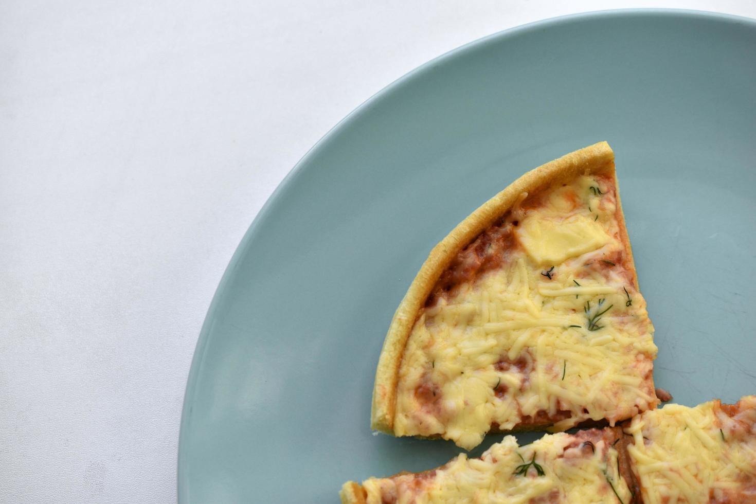 piccola pizza a buon mercato con il primo piano di formaggio su un piatto foto