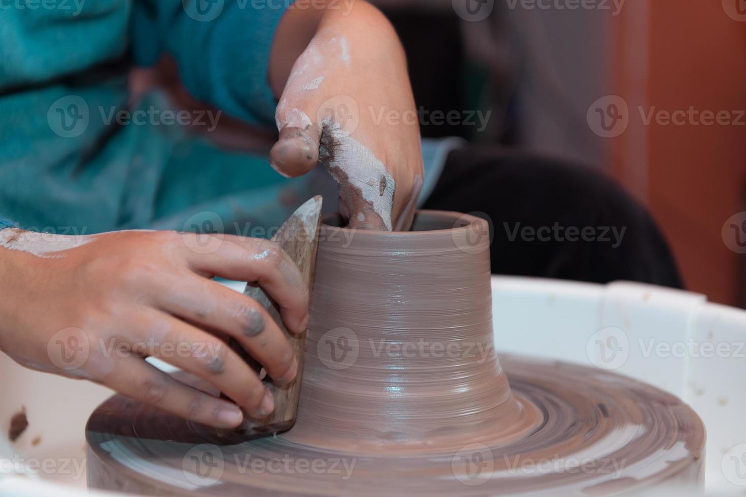 ceramica artista, giovane femmina fabbricazione un' pezzo di argilla modanatura con calma e meticolosamente nel ordine per produrre il maggior parte attraente opera possibile, foto