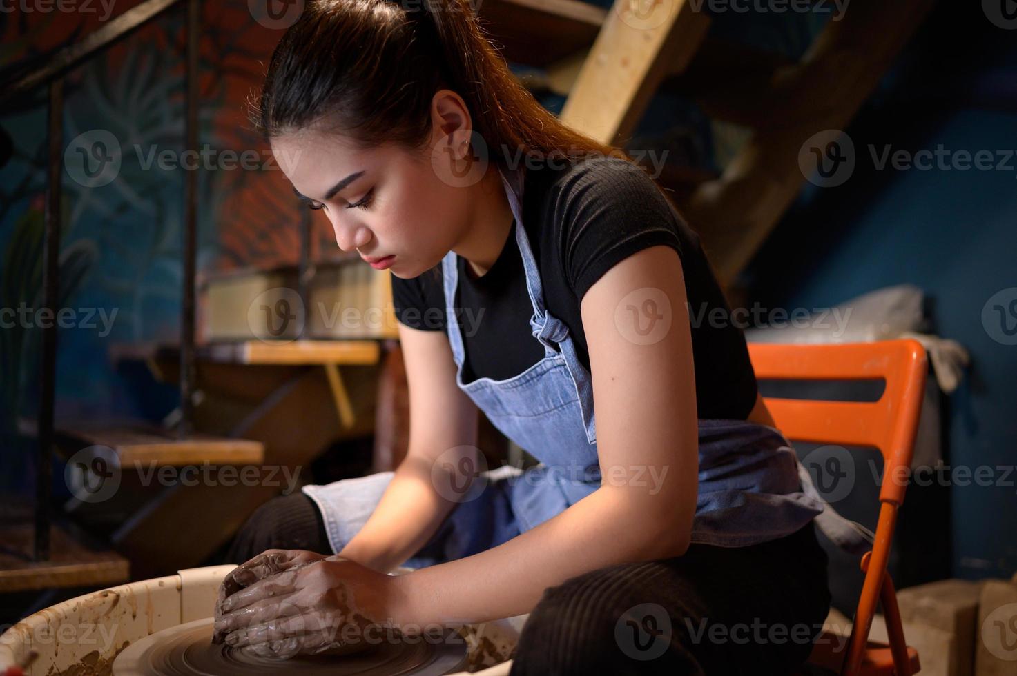 ceramica artista, giovane femmina fabbricazione un' pezzo di argilla modanatura con calma e meticolosamente nel ordine per produrre il maggior parte attraente opera possibile, foto