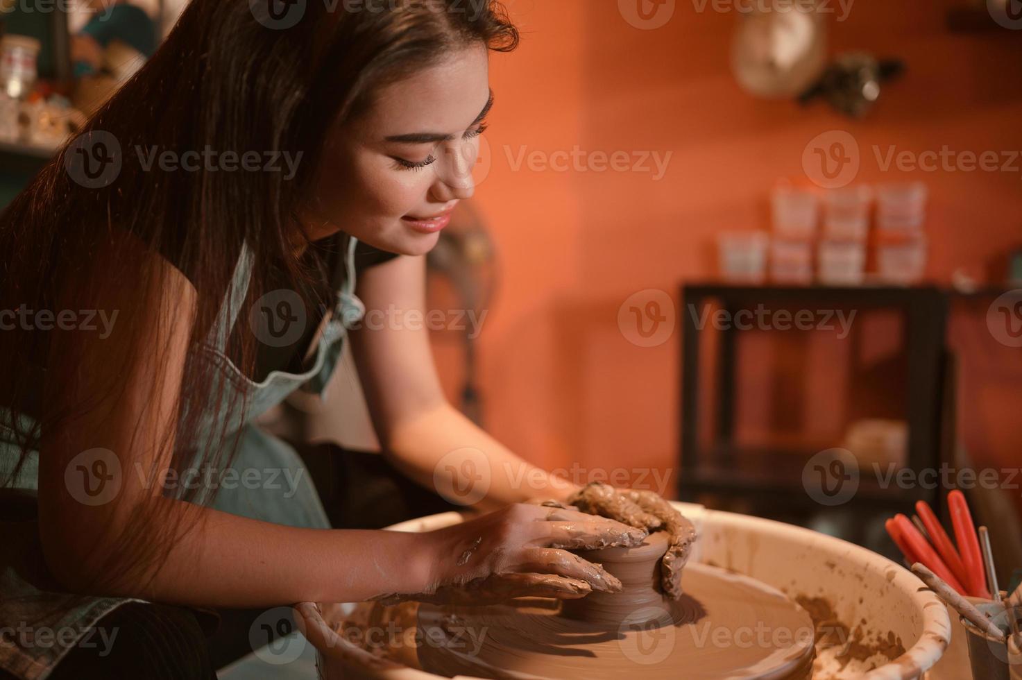 ceramica artista, giovane femmina fabbricazione un' pezzo di argilla modanatura con calma e meticolosamente nel ordine per produrre il maggior parte attraente opera possibile, foto