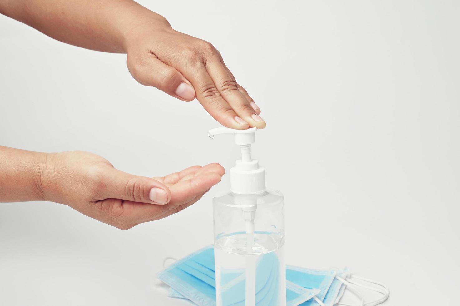 mano pompa alcool gel nel bottiglia per pulizia coronavirus covid 19 su bianca sfondo foto