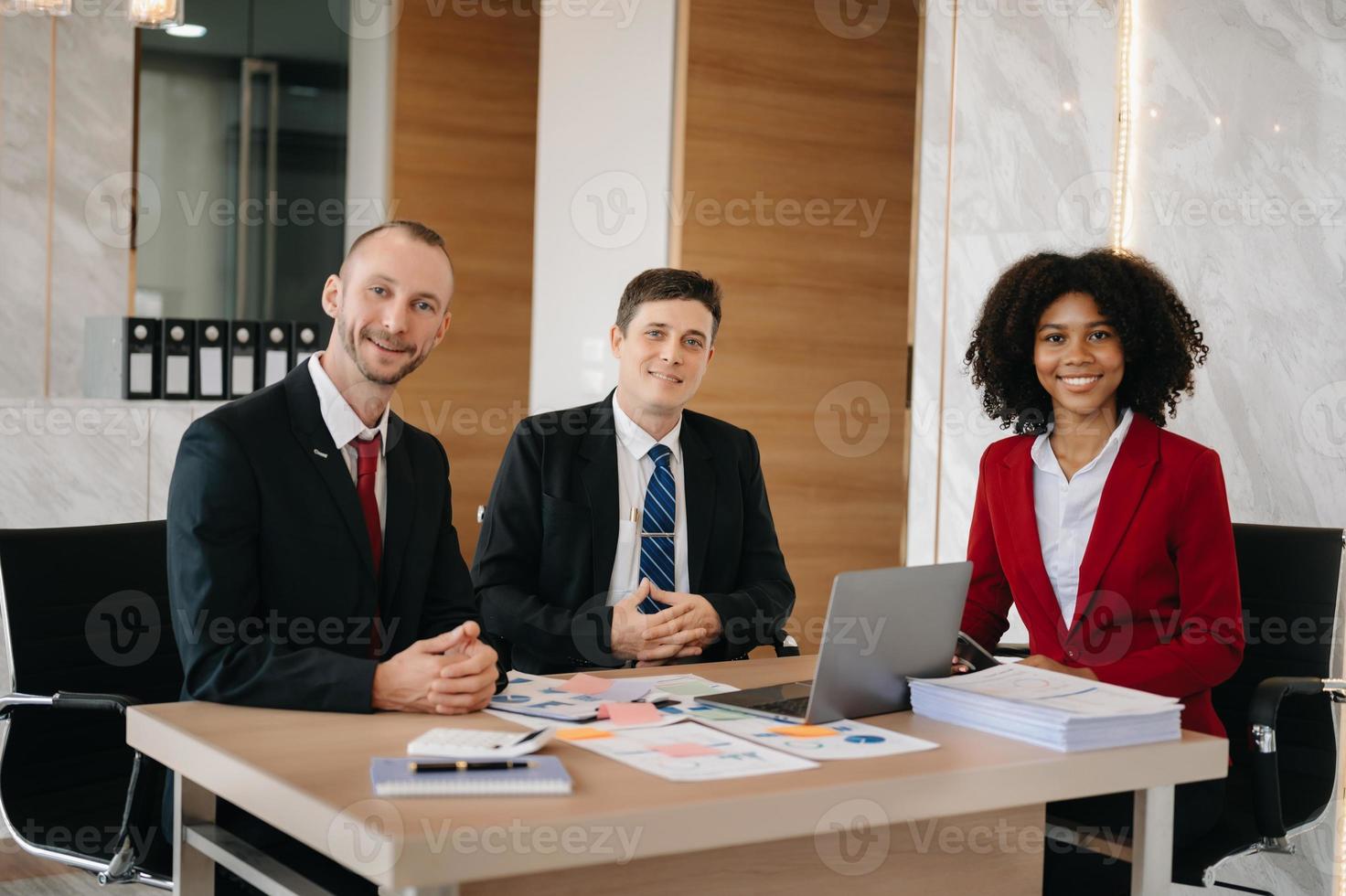 contento uomini d'affari mentre collaboratore su un' nuovo progetto nel un ufficio. gruppo di diverso uomini d'affari utilizzando un' il computer portatile e tavoletta nel ufficio. foto