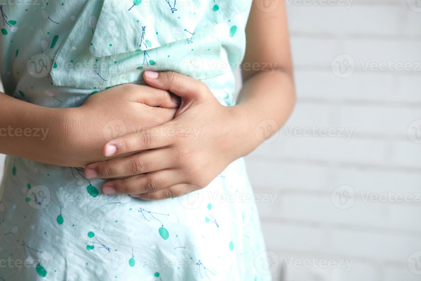 bambino che soffre di mal di stomaco da vicino foto