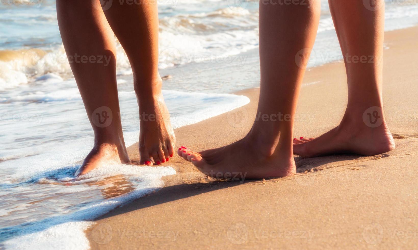 primo piano dei piedi nudi sulla sabbia foto