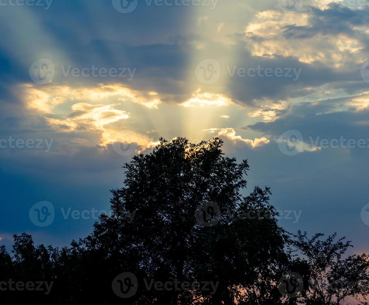 sole al tramonto e cielo blu foto