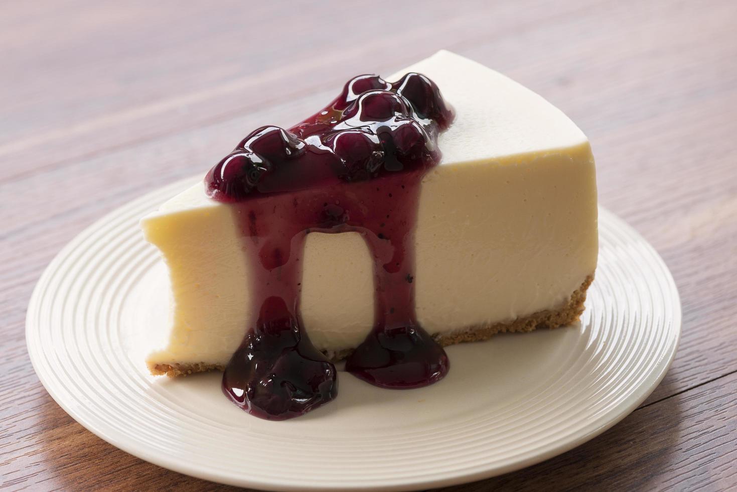 Cheesecake alla crema di mirtilli su un piatto bianco su un tavolo di legno foto