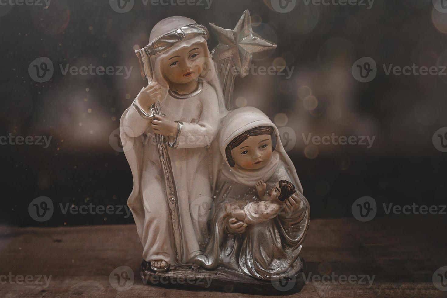 ceramica figurine di il madre di Dio Giuseppe e bambino Gesù per il Natività scena su un' buio Marrone sfondo foto