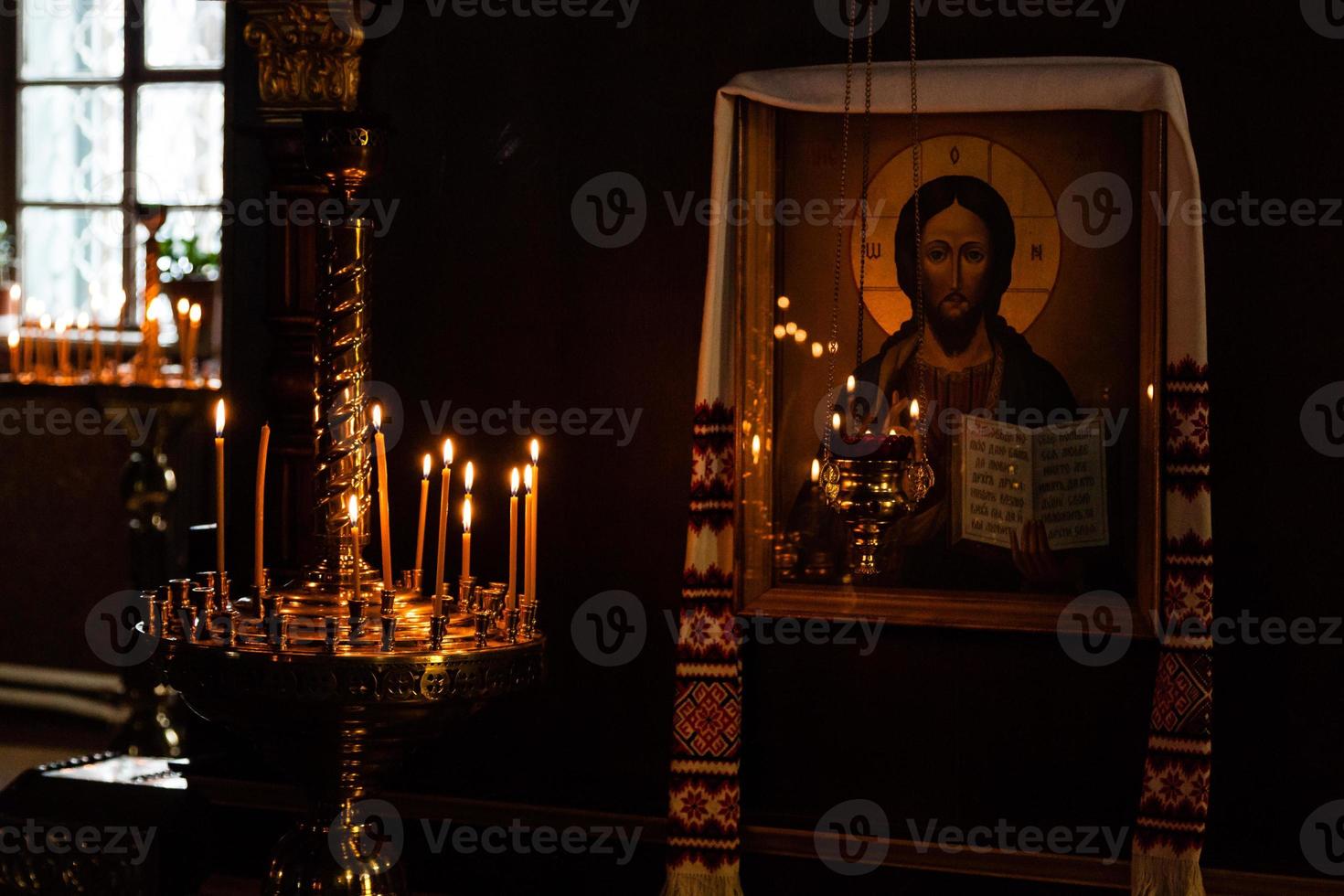 Chiesa candele bruciare nel un' candeliere contro il fondale di icone foto