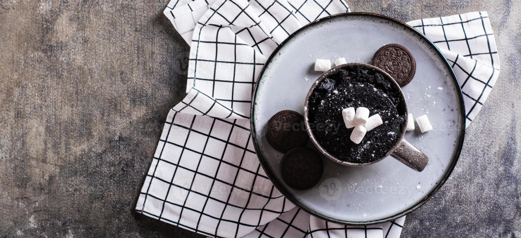 Presto cioccolato torta boccale con marshmallows su un' piatto su il tavolo superiore Visualizza ragnatela bandiera foto