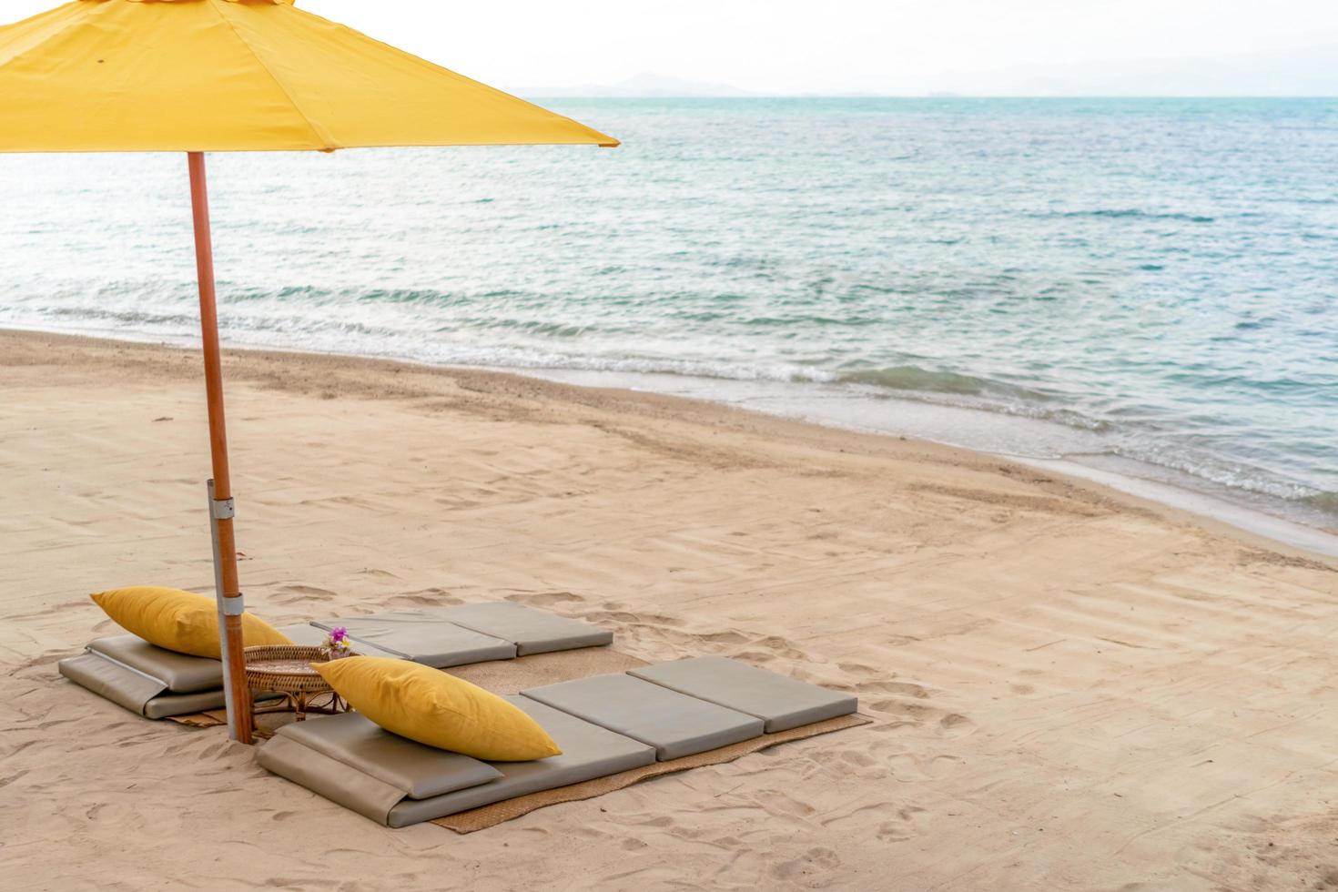 ombrellone e sedia in uno sfondo di spiaggia estiva tropicale con cielo blu dello spazio della copia foto
