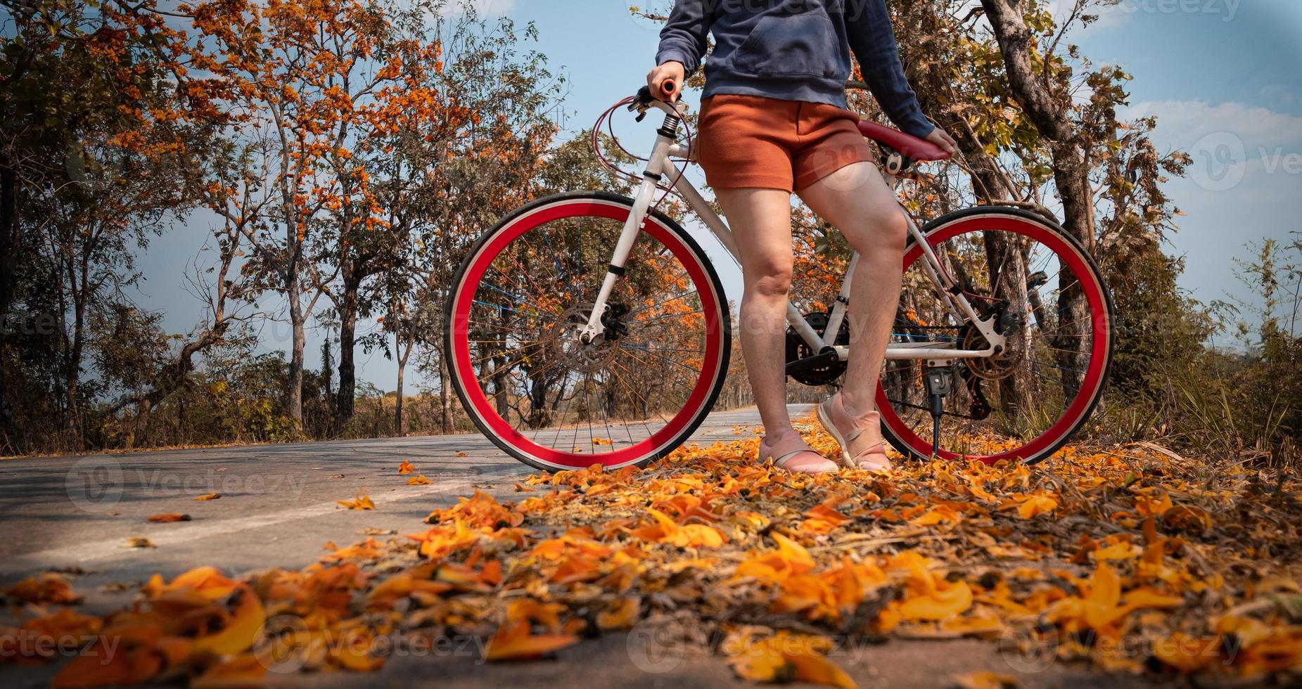 donna in piedi accanto alla sua bici all'aperto foto