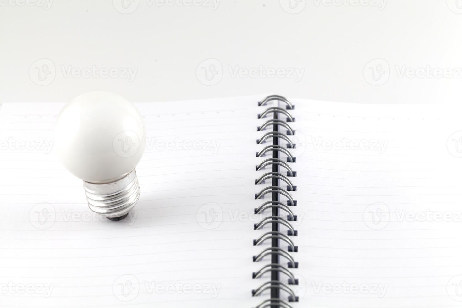 notebook e lampadina isolato su uno sfondo bianco foto