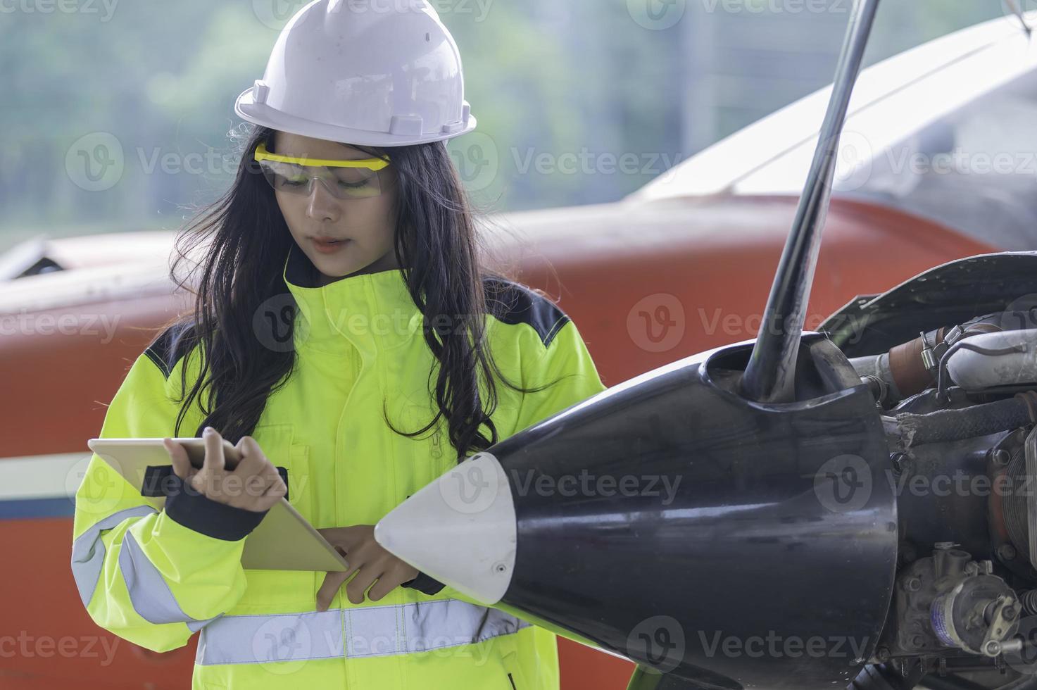 tecnico che ripara il motore dell'aereo, ingegneria aerospaziale femminile che controlla i motori degli aerei, manutenzione meccanica asiatica ispeziona il motore dell'aereo foto