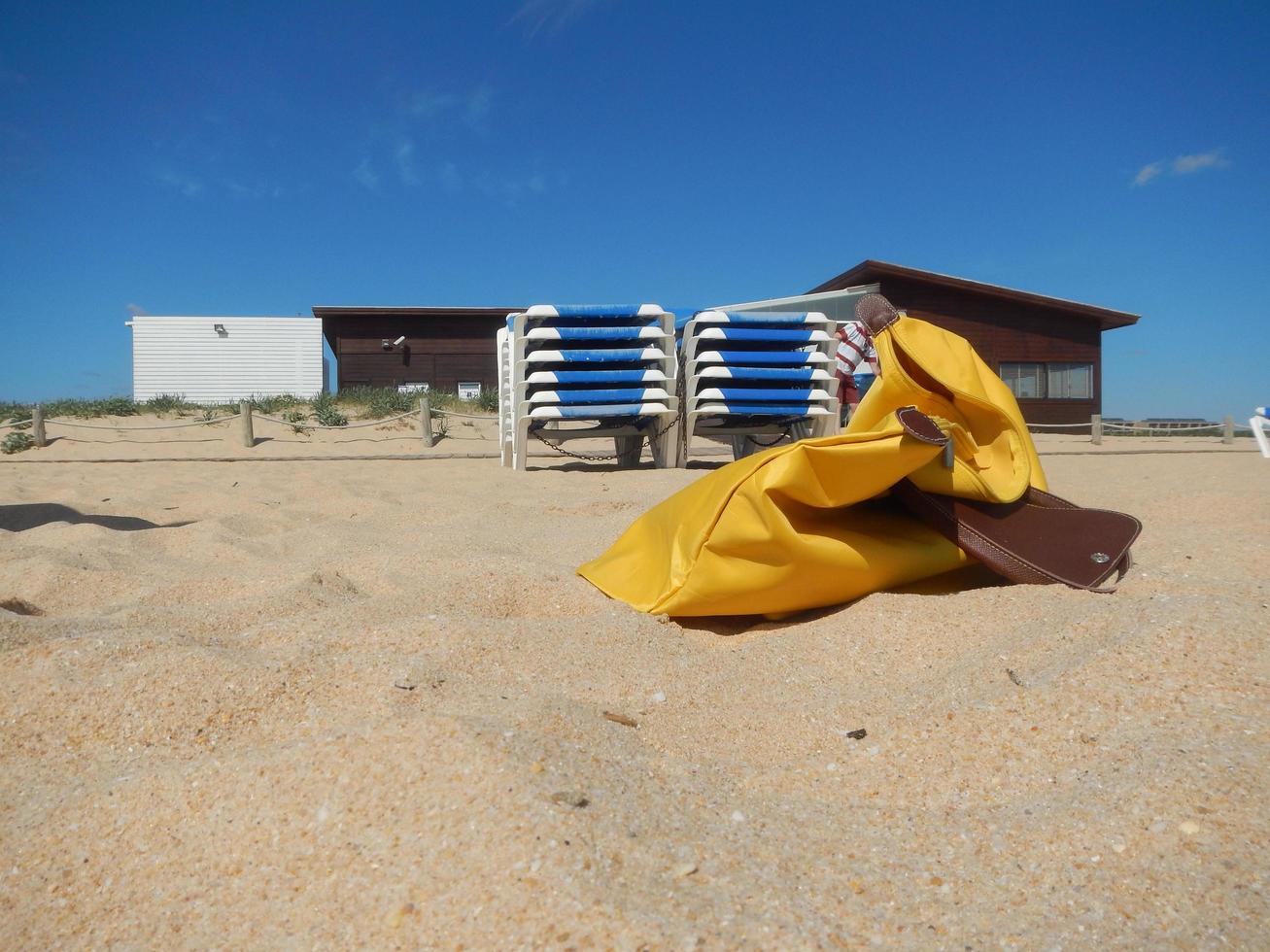 borsa gialla sulla sabbia di una spiaggia in Algarve vicino ad Albufeira foto