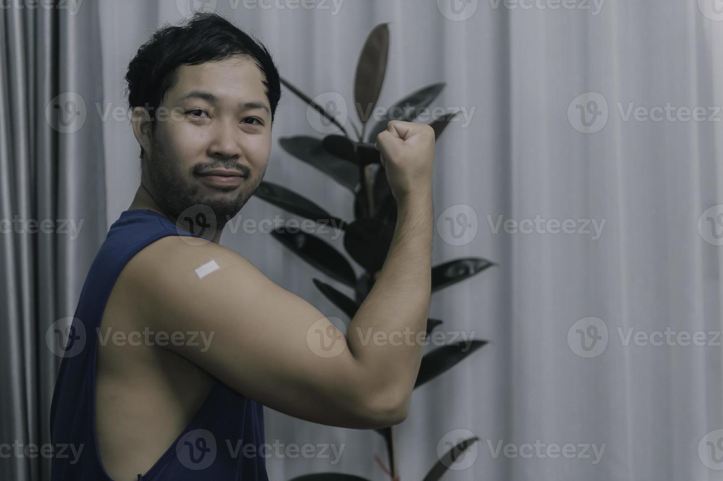 asiatico bello uomo mostrando vaccinati braccio, prendi vaccinati per proteggere contro covid-19, antivirus corona virus concetto foto