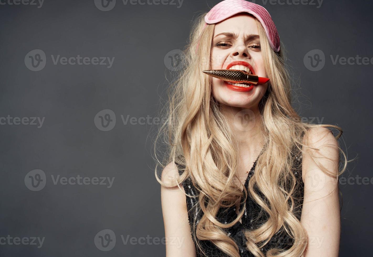 ubriaco donna con rossetto nel mano e rosa maschera su sua viso foto