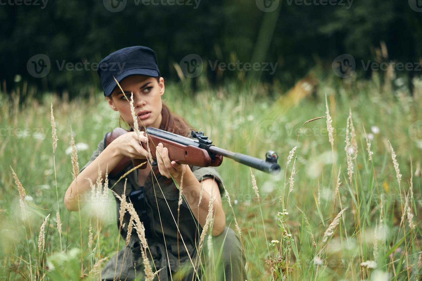 donna su all'aperto a caccia è seduta su il erba verde le foglie foto